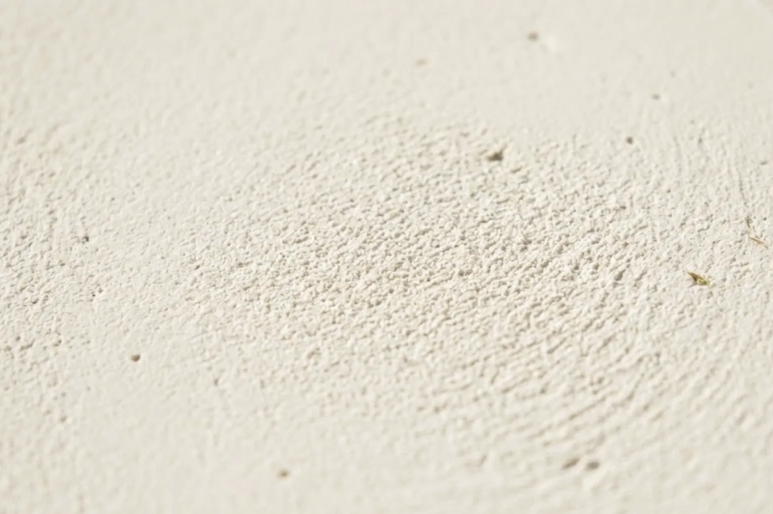 Zoom sur une finition talochée à la chaux sur parpaing, texture finale de l'enduit bâtard