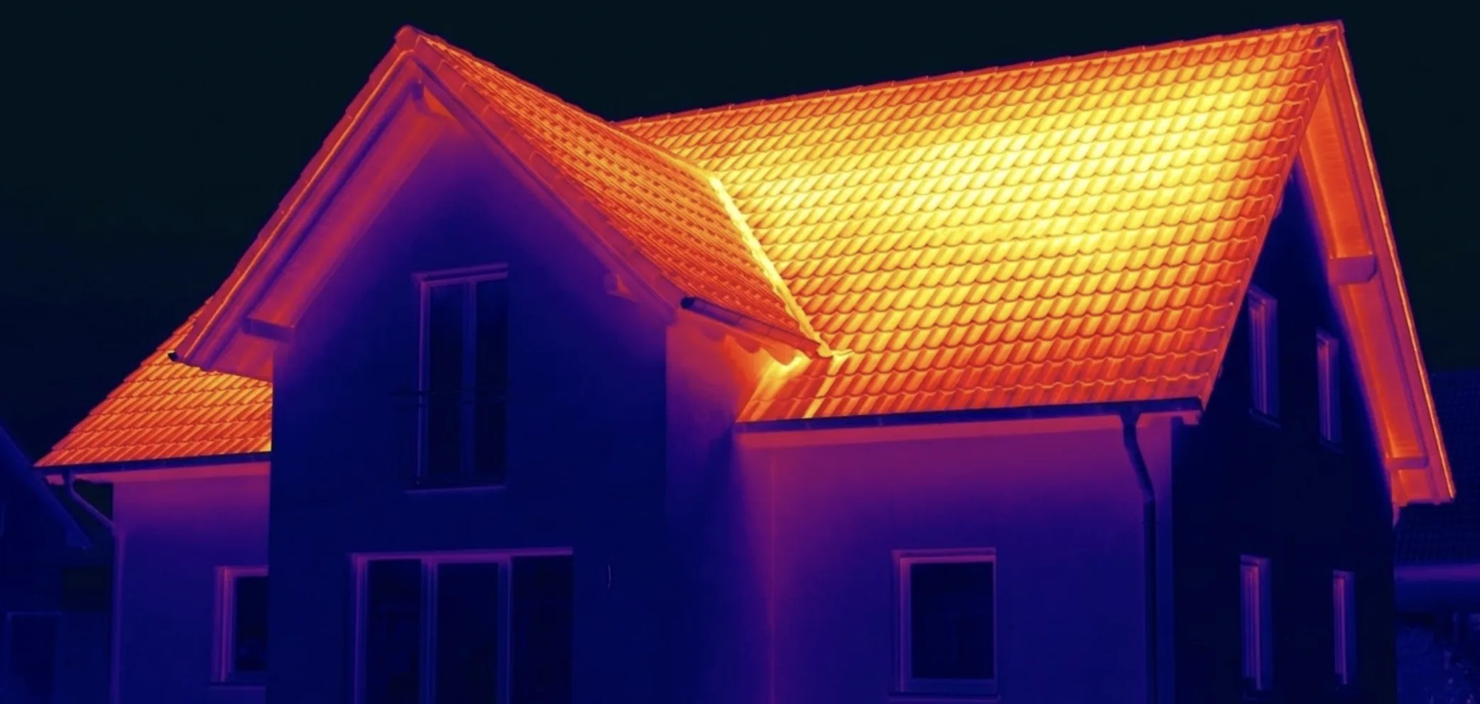 Artisan RGE utilisant une machine cardeuse pour souffler des flocons de laine de verre dans des combles perdus